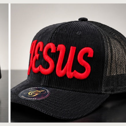 Angled black corduroy trucker snapback with red Jesus Script 3D puff embroidery on a clean studio background