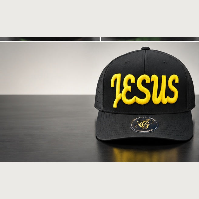 Black perforated snapback with yellow Jesus Script 3D puff embroidery on a clean studio background