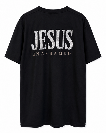 Back view of black AS Colour Heavy T Shirt with stonewashed JESUS UNASHAMED full back design on white background