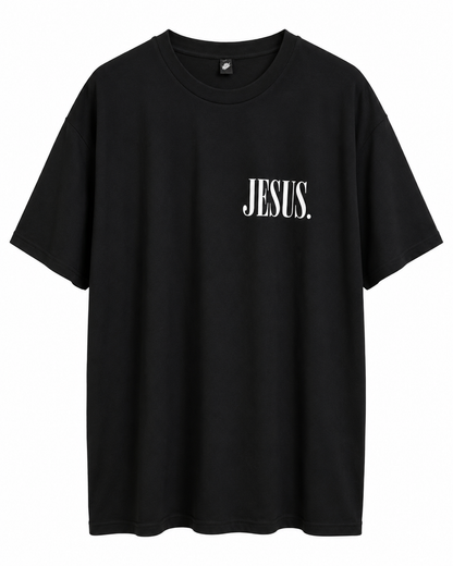 Front view of black AS Colour Heavy T Shirt with white JESUS left chest print on white background